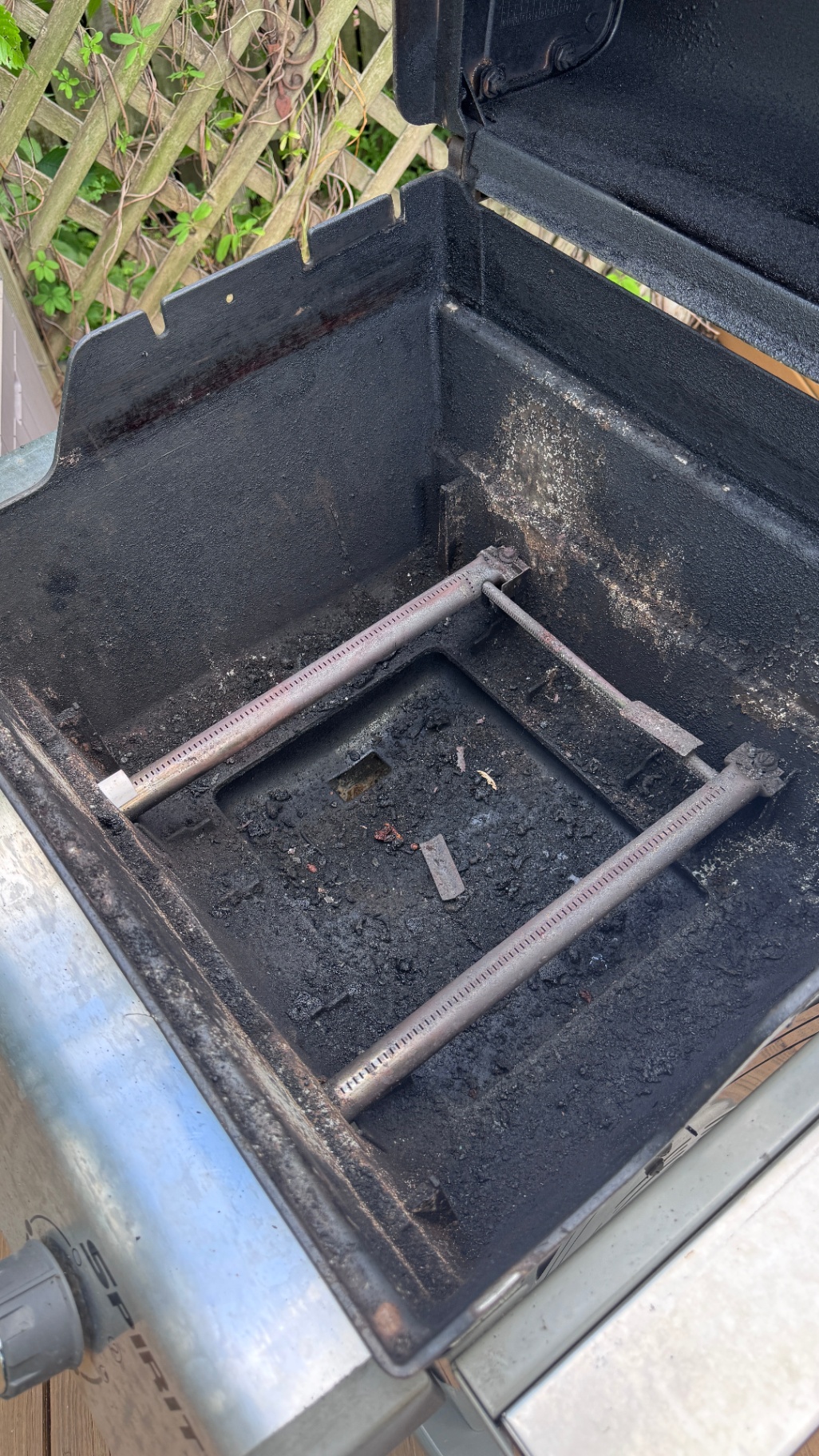 Dirty Weber Spirit firebox with heavy grease, carbon buildup, and exposed burner tubes before a Campbell Grill Detail deep clean.
