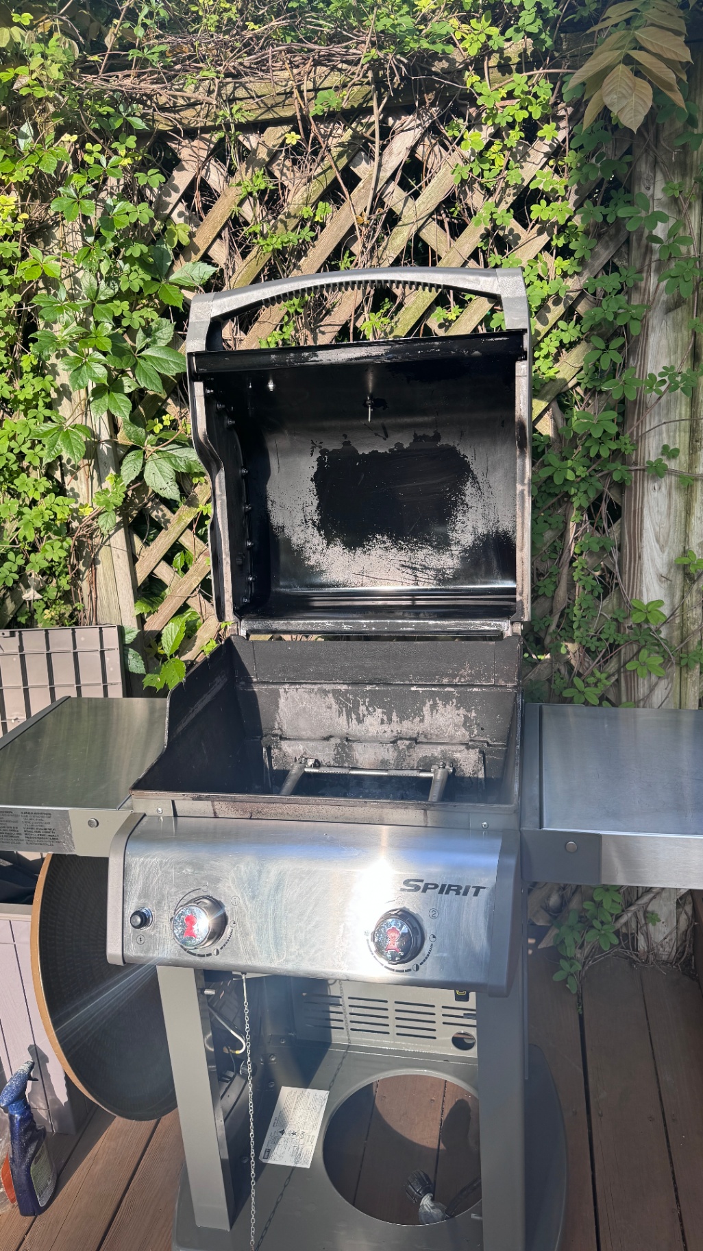 Carbonized grease flaking inside a Weber Spirit gas grill lid, commonly mistaken for peeling paint by homeowners.